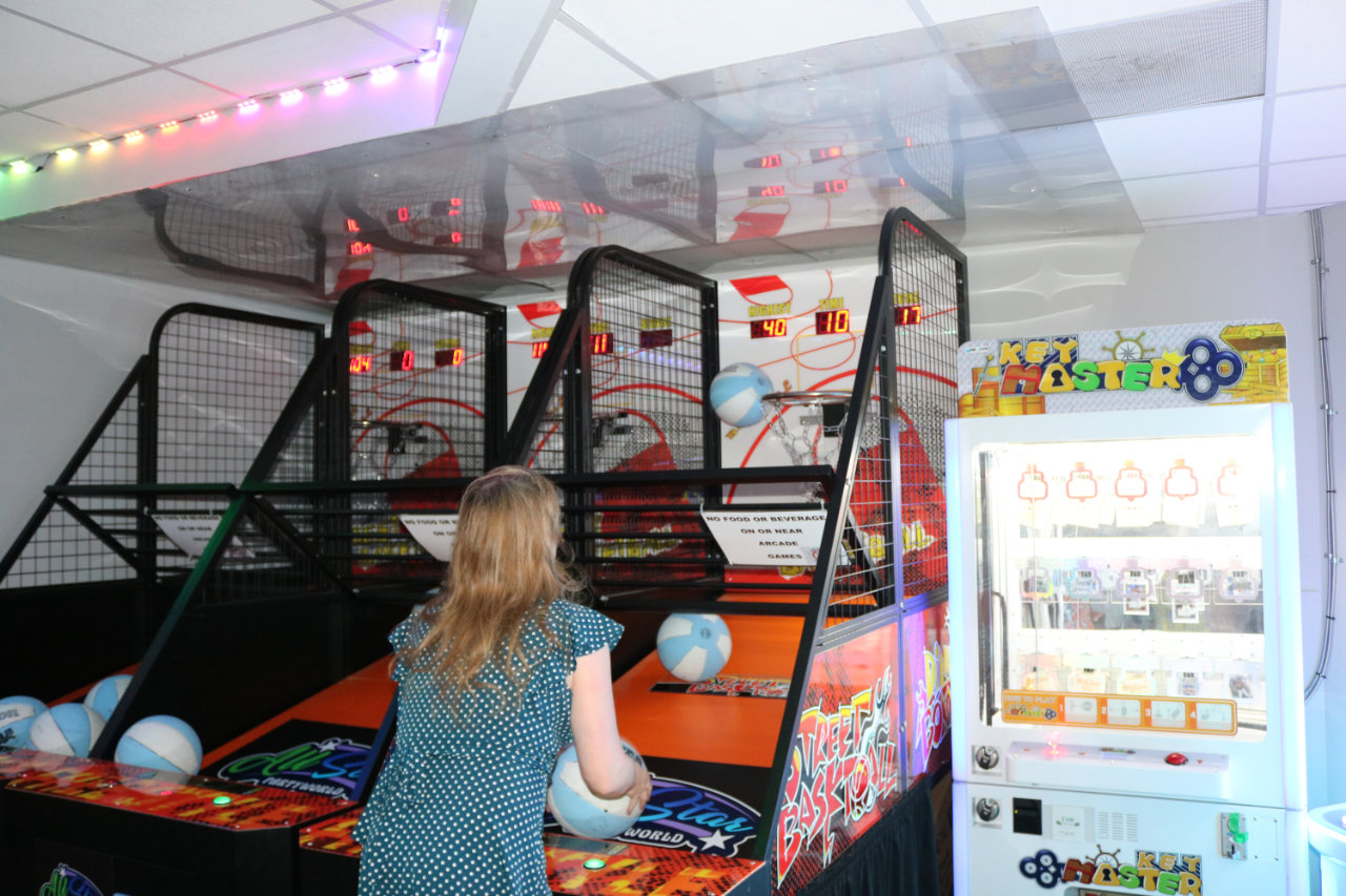 Player taking a shot at arcade basketball at All Star Party World
