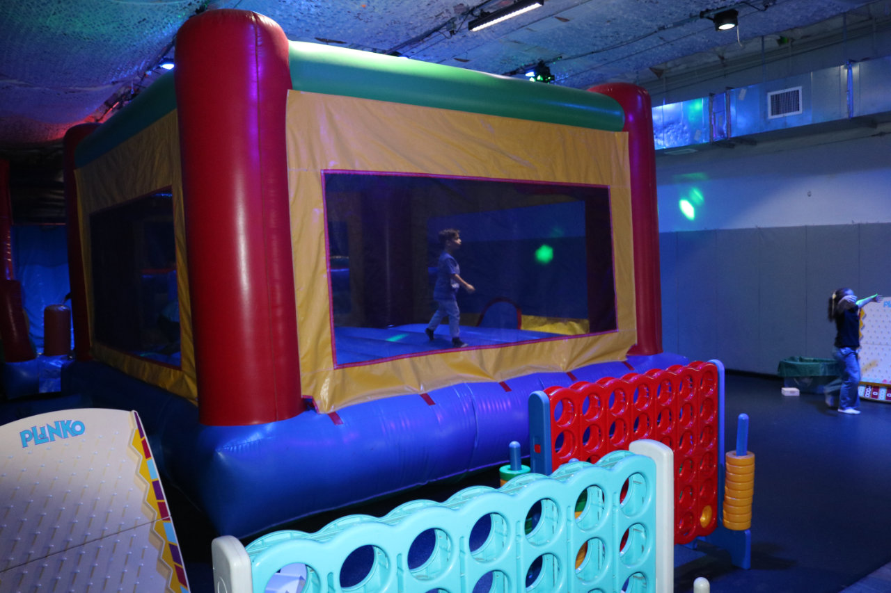 Bounce house area with Connect Four game at All Star Party World