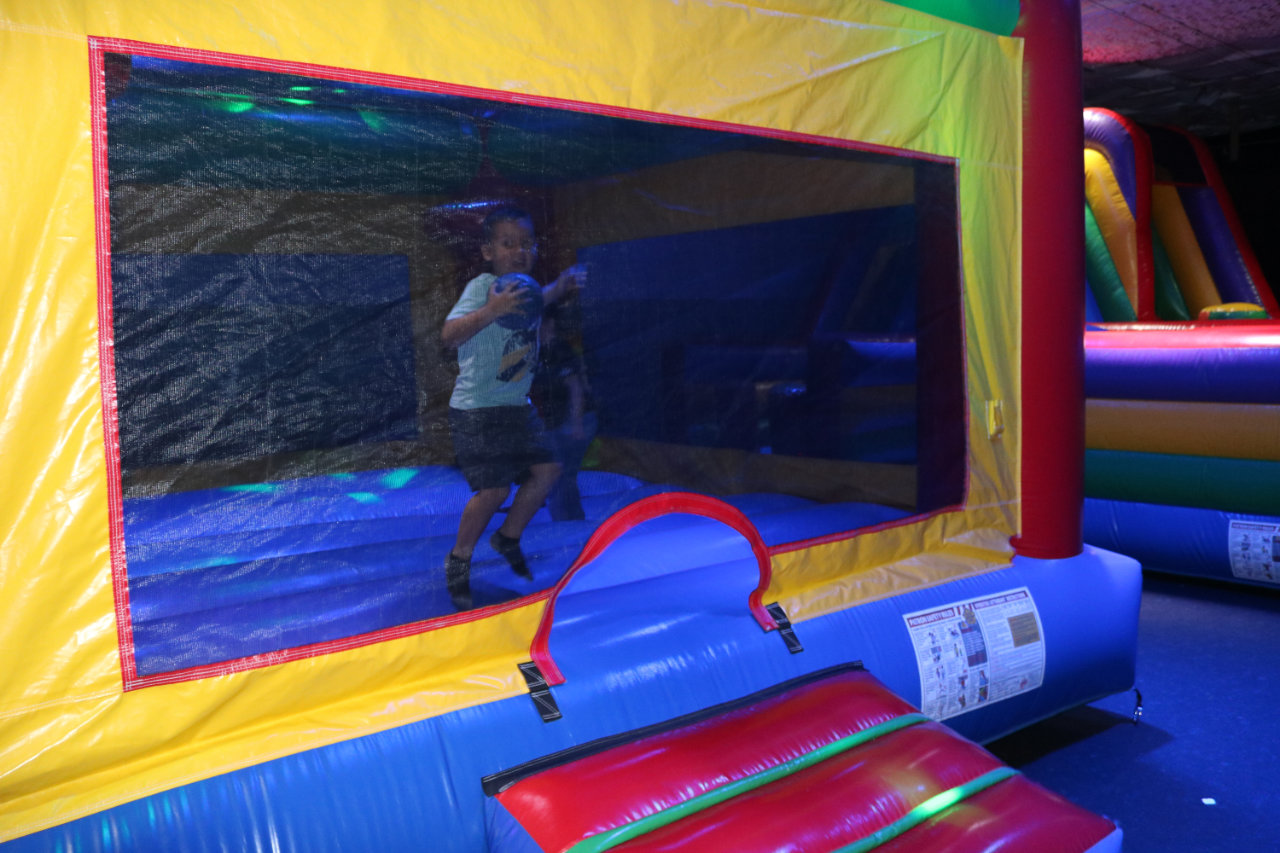 Boy jumping on the bounce house trampoline at All Star Party World