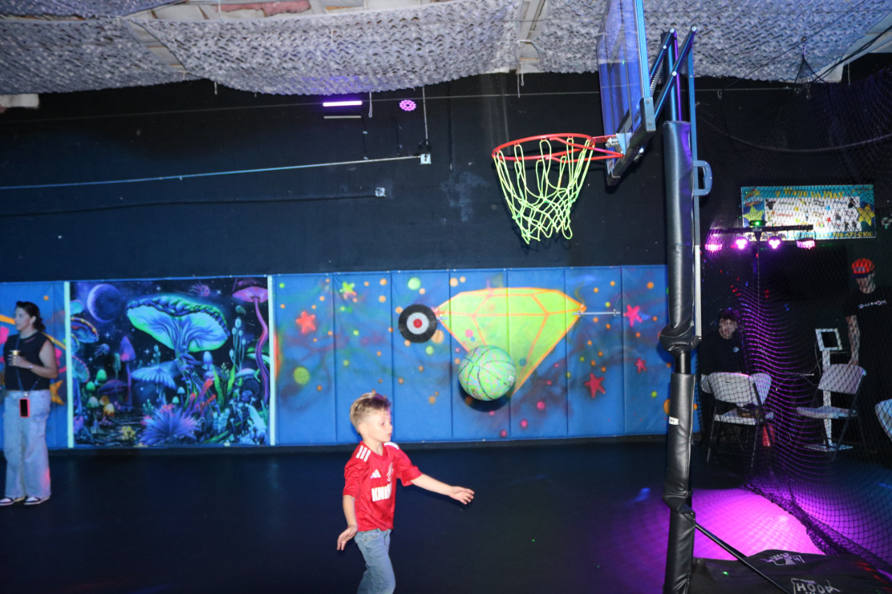 Boy in red shirt playing basketball at All Star Party World