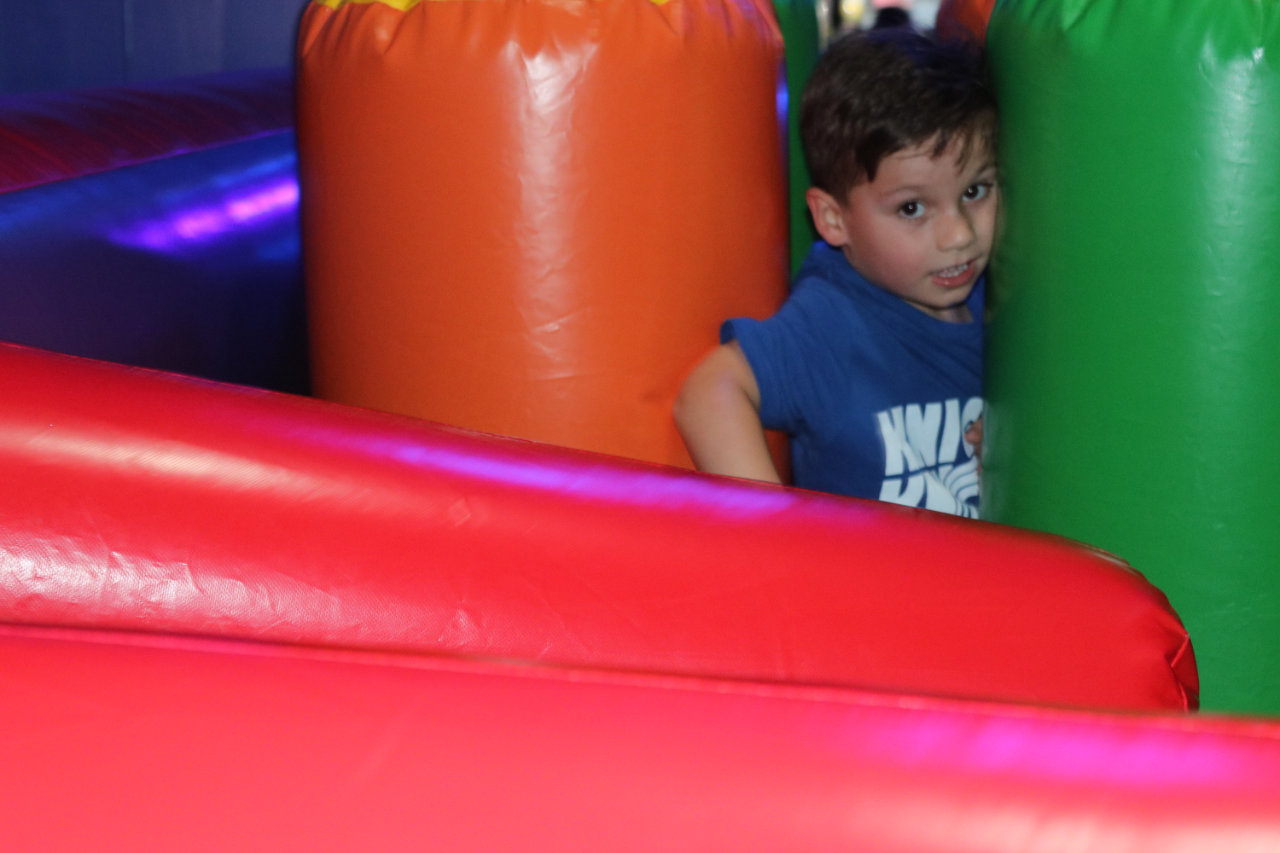 Child playing behind the inflatable wall at All Star Party World