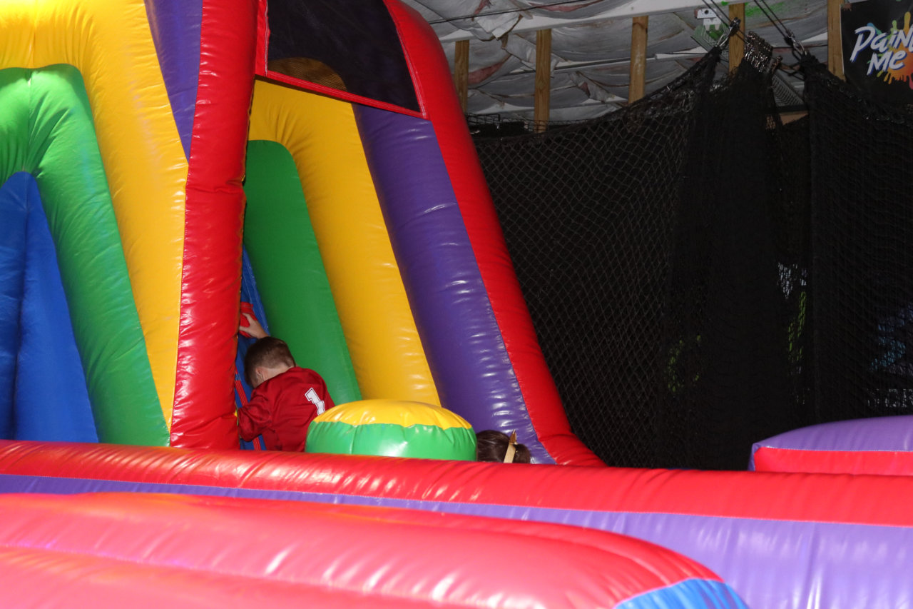 Child climbing up the inflatable slide at All Star Party World
