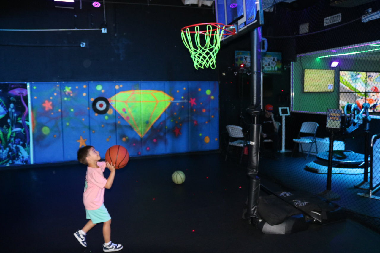Child dribbling a basketball at All Star Party World