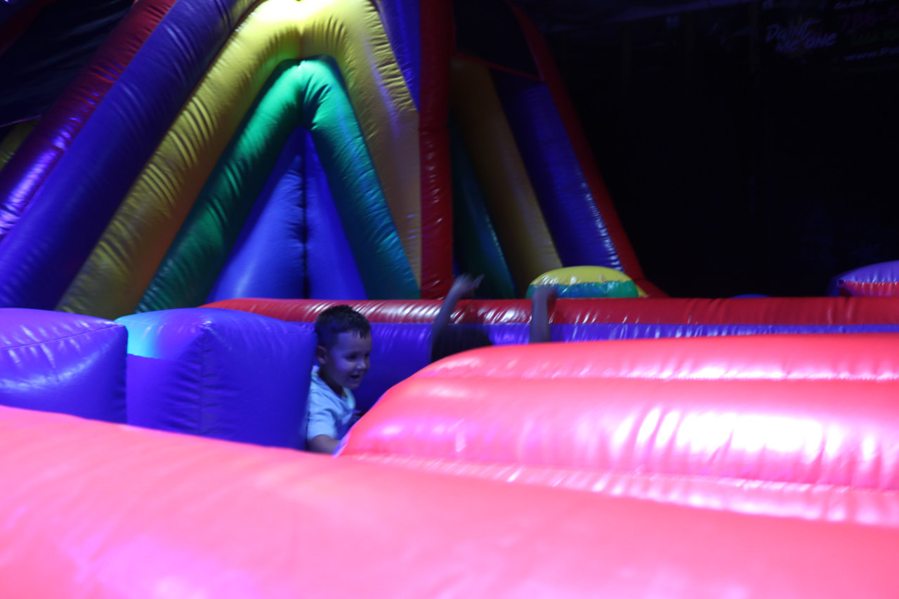 Child peeking over the inflatable obstacle at All Star Party World