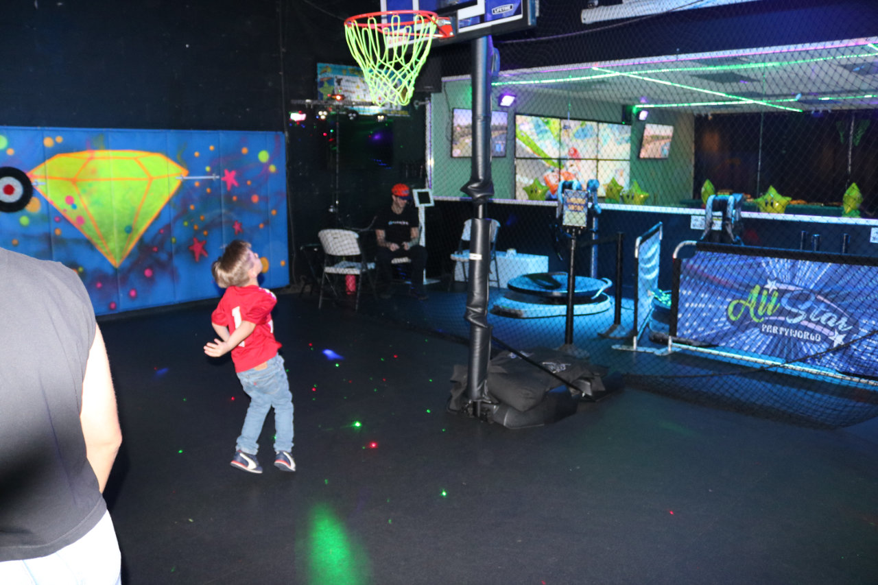 Child shooting a basketball at All Star Party World