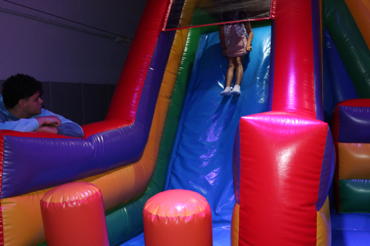 Child sliding down the inflatable slide at All Star Party World