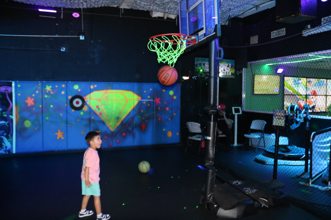 Child standing under a basketball hoop at All Star Party World