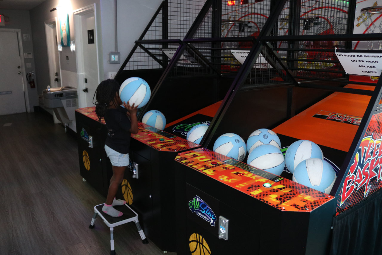 Child stepping up to the basketball arcade at All Star Party World