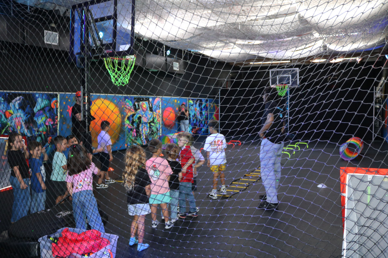 Coach leading kids in a basketball game at All Star Party World