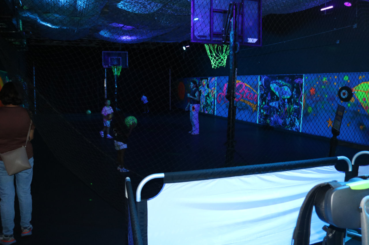 Dark basketball court with glowing hoops at All Star Party World