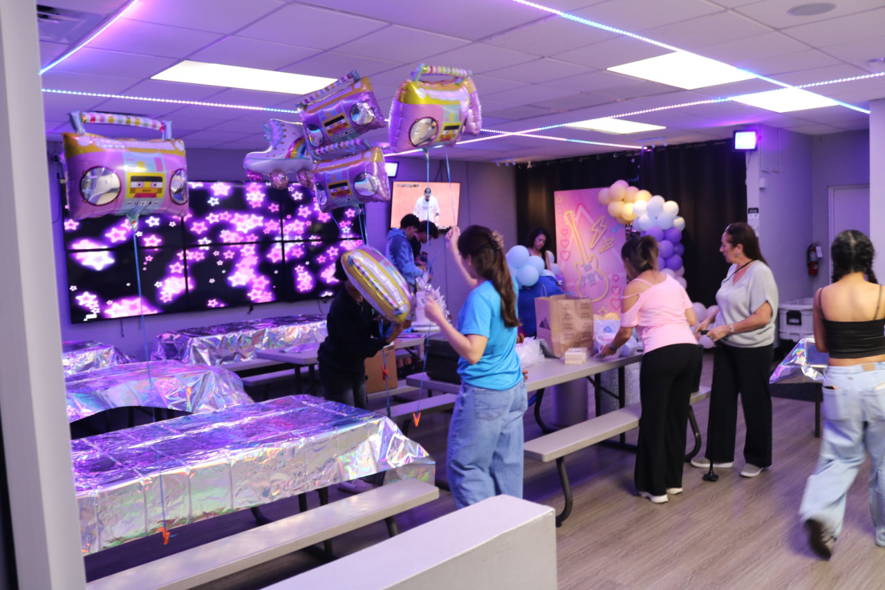 Foil party table setup with flower wall backdrop at All Star Party World