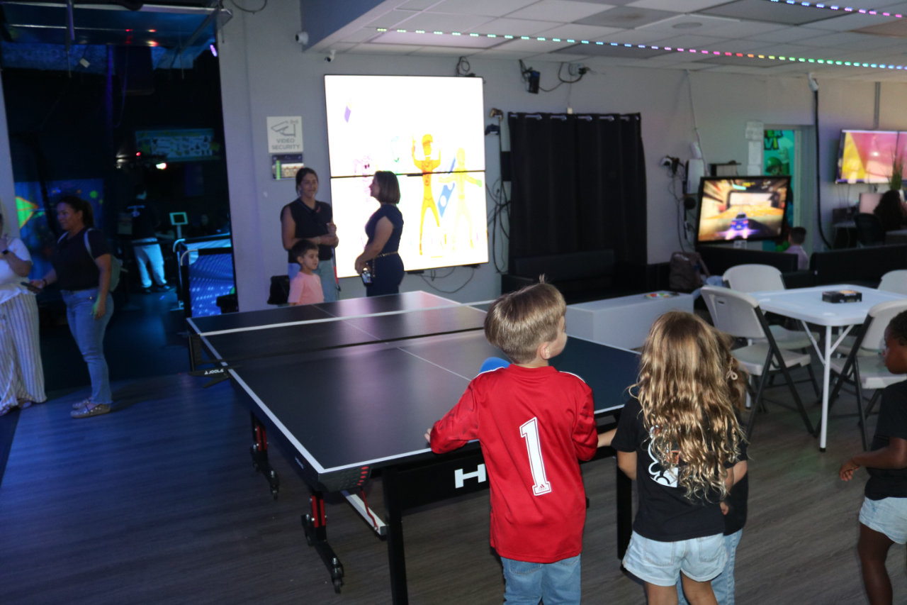 Group gathered near ping pong table at All Star Party World