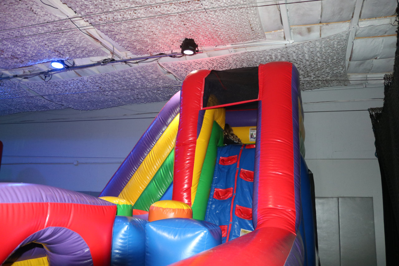 Kids descending the inflatable slide at All Star Party World
