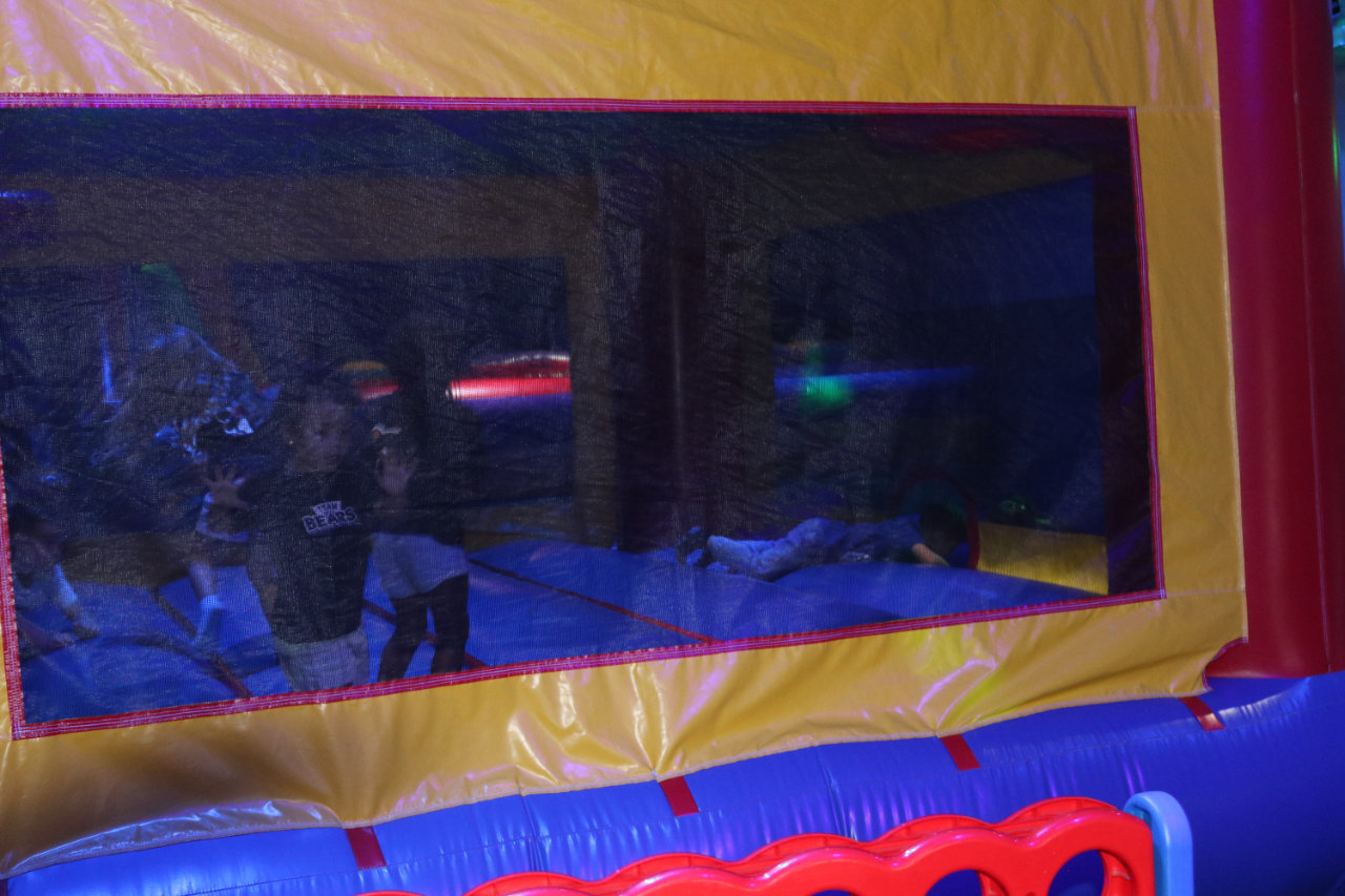 Kids visible through the bounce house window at All Star Party World
