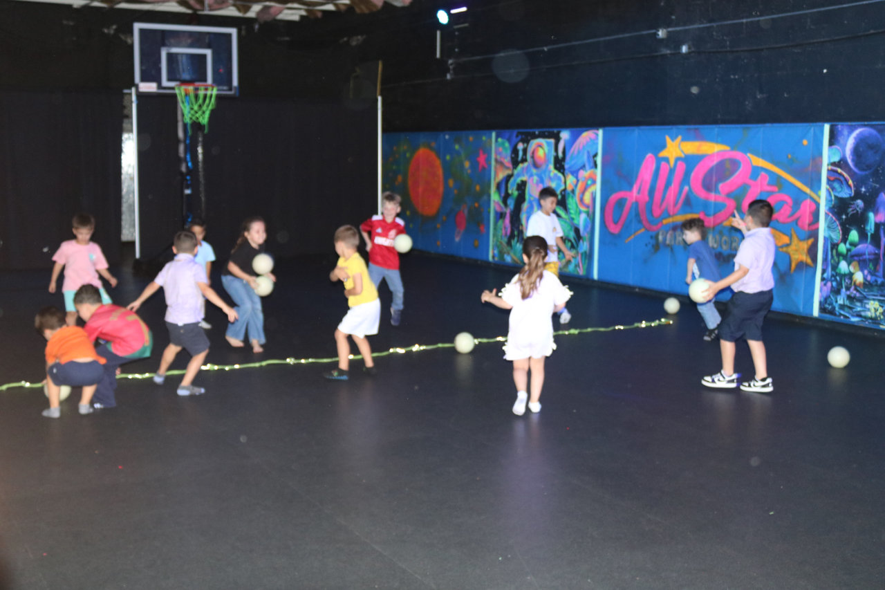 Kids running on the basketball court at All Star Party World