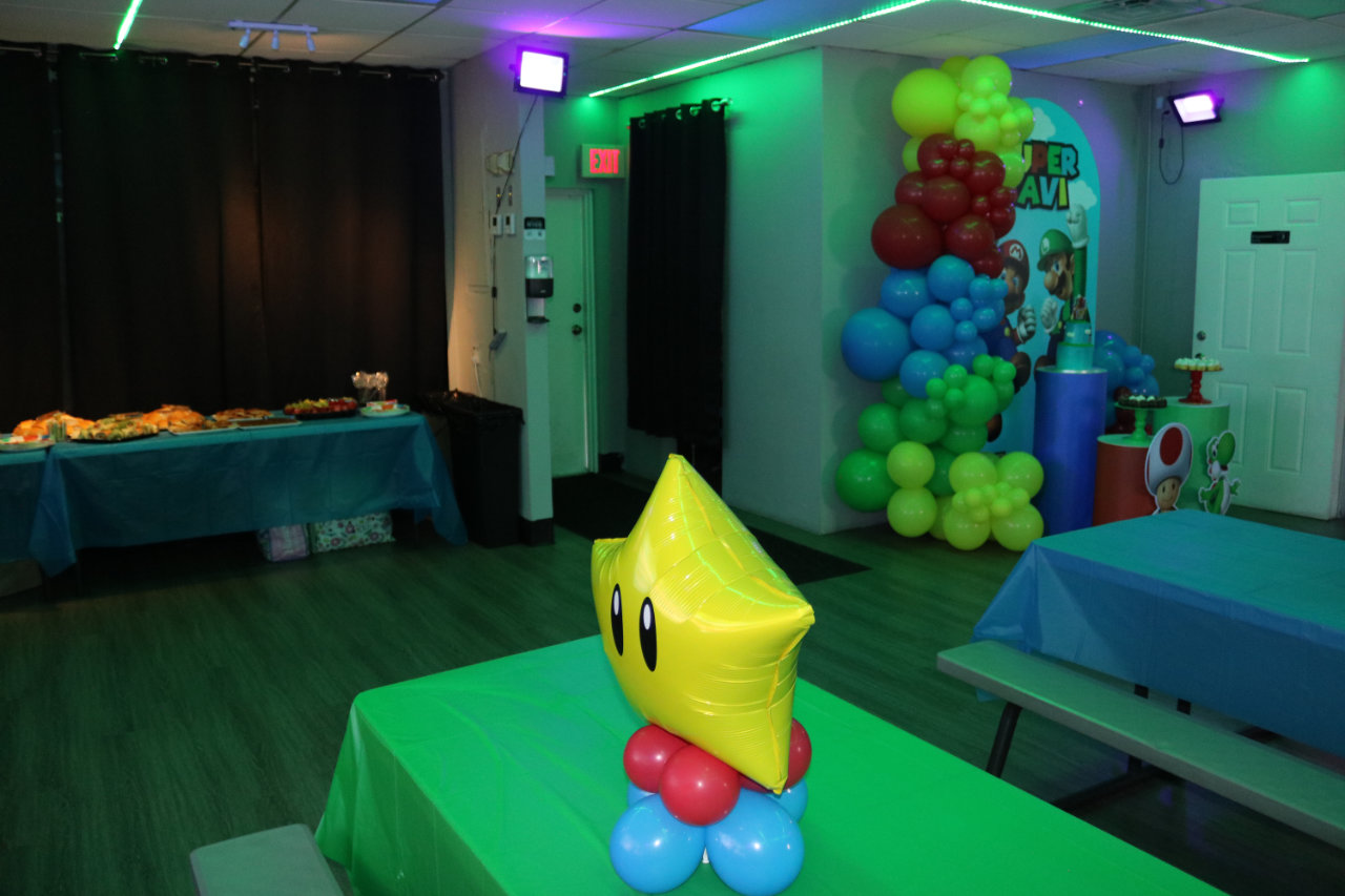 Mario themed party tables with balloon arch at All Star Party World