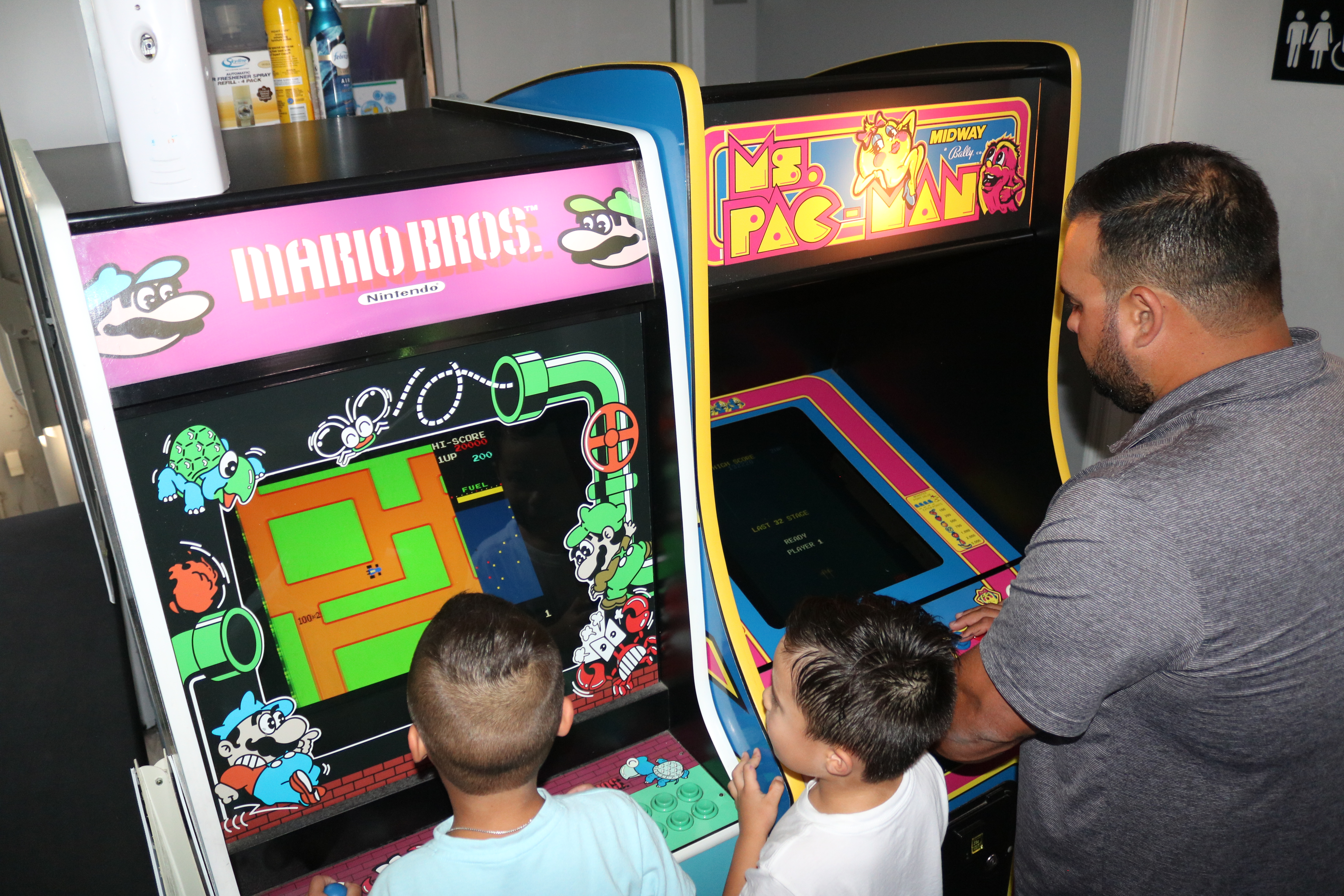 Family playing Pac-Man arcade game at All Star Party World