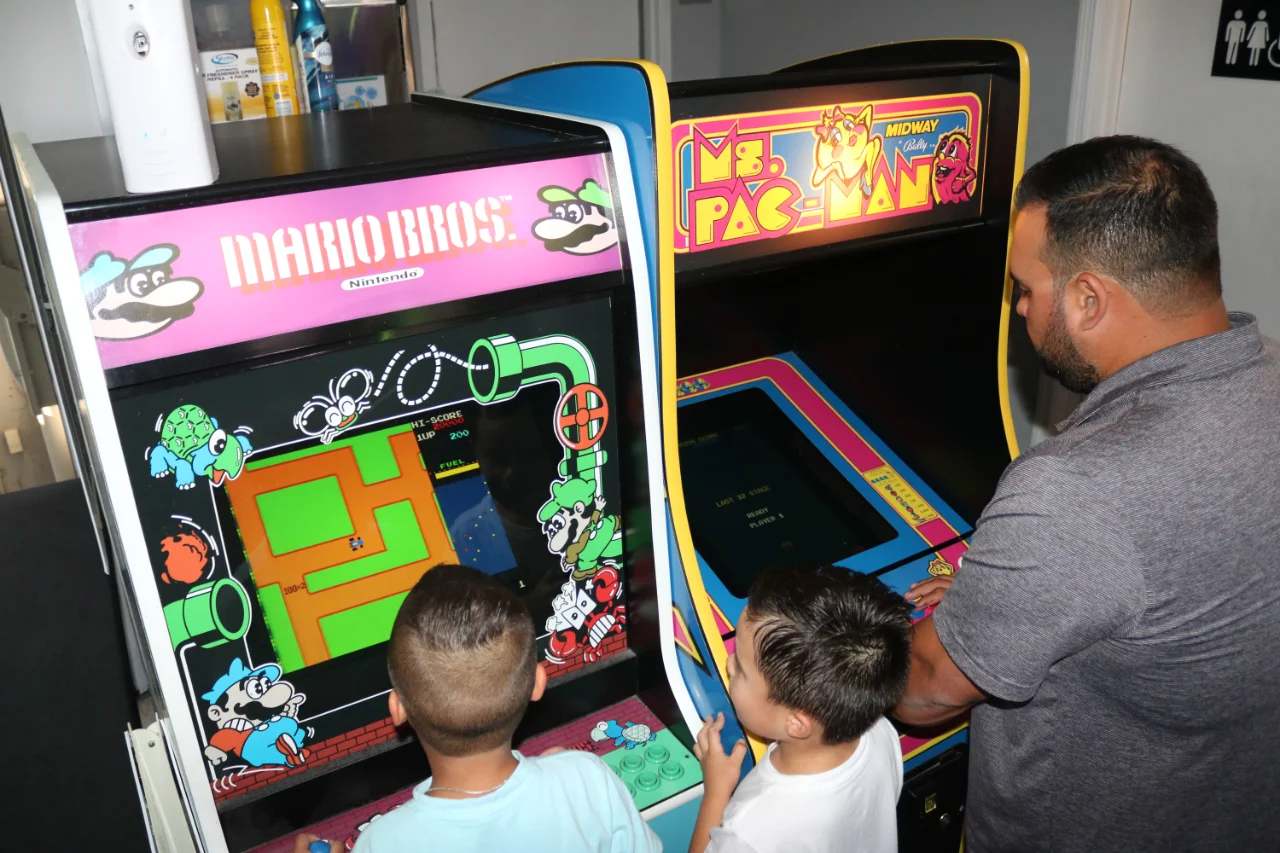Family playing Pac-Man arcade game at All Star Party World