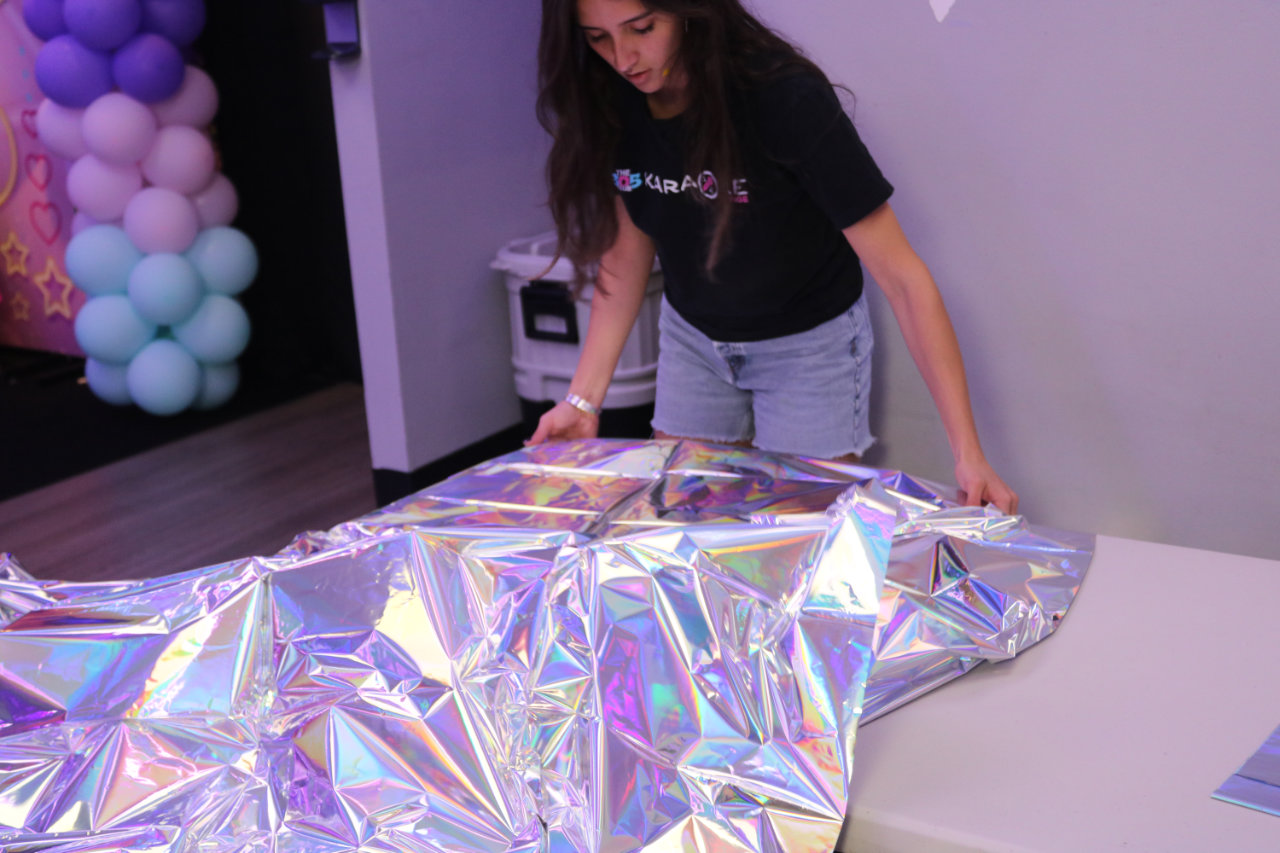 Staff setting up a foil party table at All Star Party World