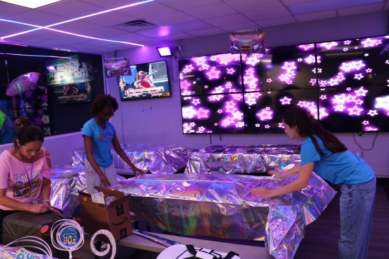 Staff setting up party tables at All Star Party World