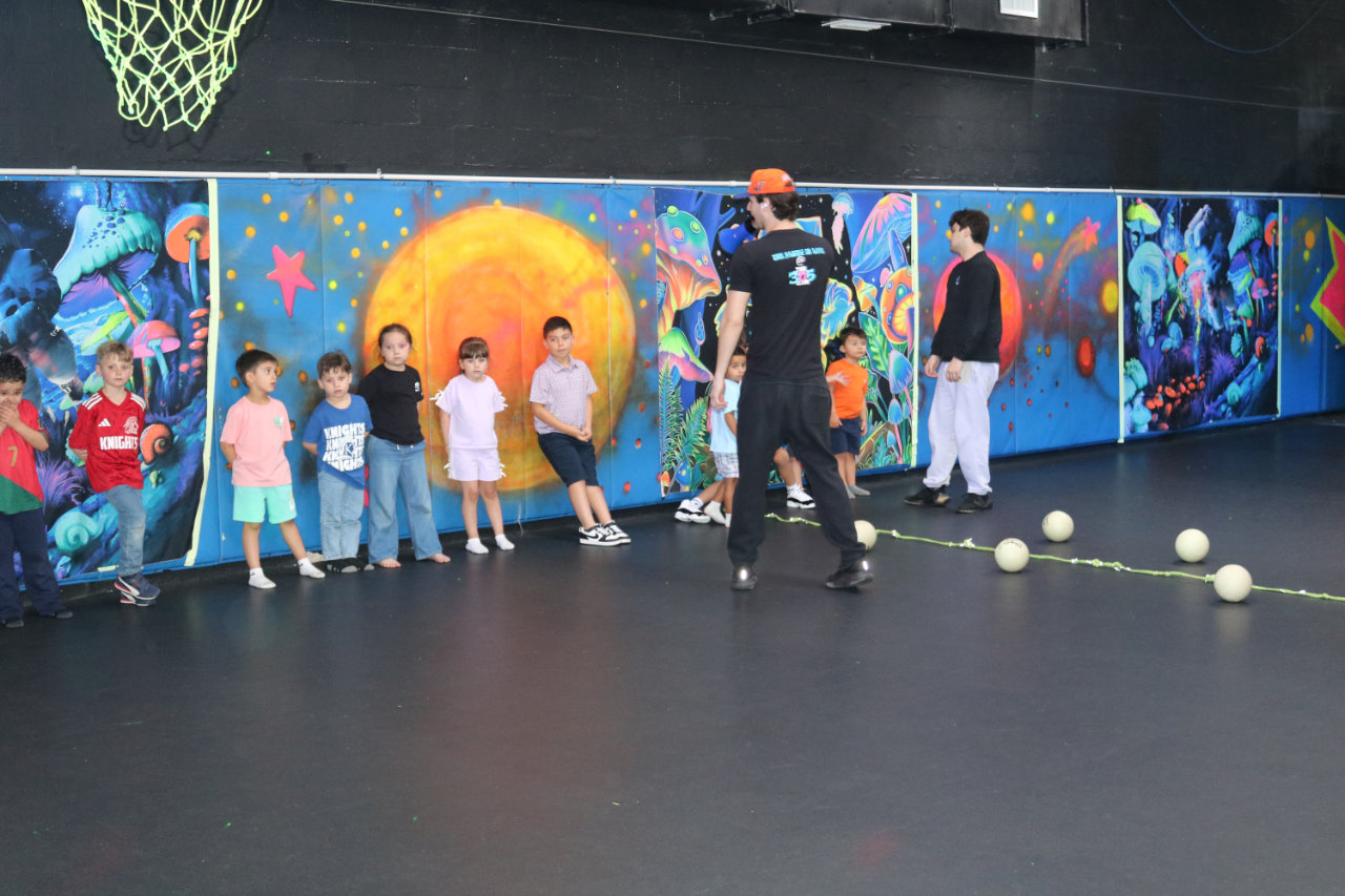 Wide group photo on the basketball court at All Star Party World