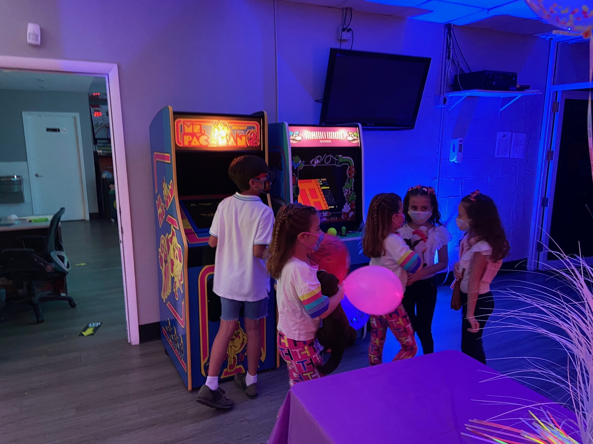 Kids playing classic arcade games including Pac-Man and Mario at All Star Party World