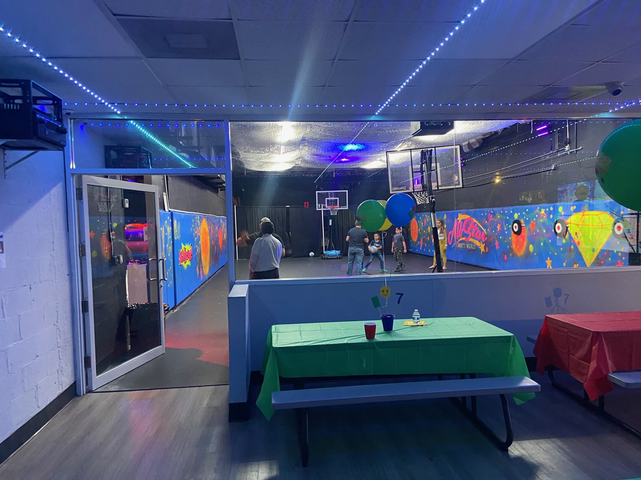 All Star Party World party room with basketball court, balloon decorations, and party tables set up